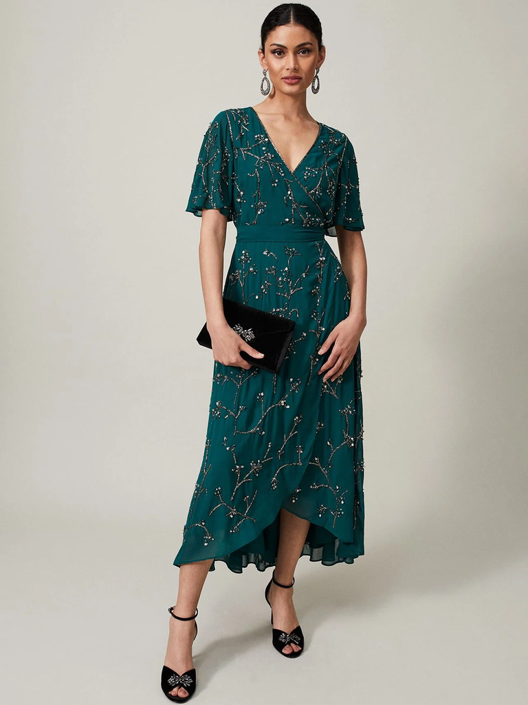A model wears this showstopping jewel-toned gown with a V-neck and fluttery sleeves.