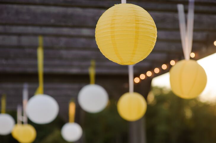 White and yellow paper lanterns hung above the couple during the ceremony.