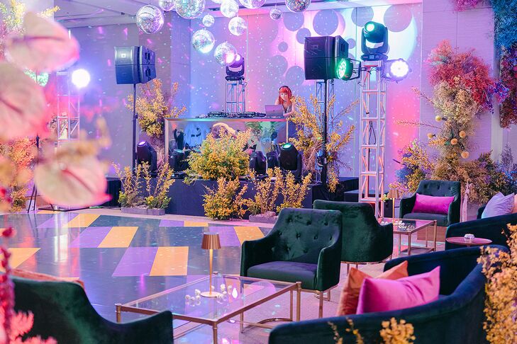 A funky colorful disco reception with a custom, colorful dance floor, disco balls, glass coffee tables, lounge furniture and pink, purple and blue uplighting for a fun wedding reception and after party for an LGBTQ+ couple.