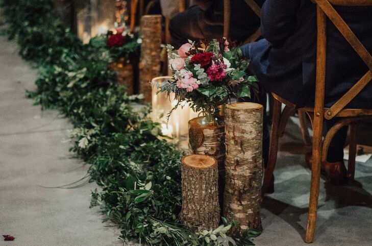 Rustic Winter Aisle Decorations of Greenery, Tree Stumps and Flowers