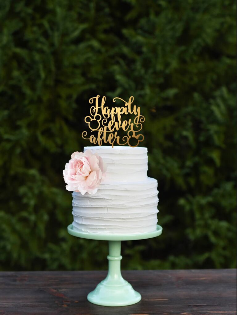 Gold cake topper in classic calligraphy with two Mickey icons