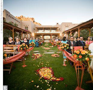 Coordinating iron stands with bouquets of orange roses lined the aisle.
