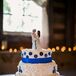 Josh's mother made the ivory wedding cake, which was decorated with blue sugar flowers and ribbon around the base of the layers. A bride and groom figurine set resembling Justine and Josh served as the cake topper.