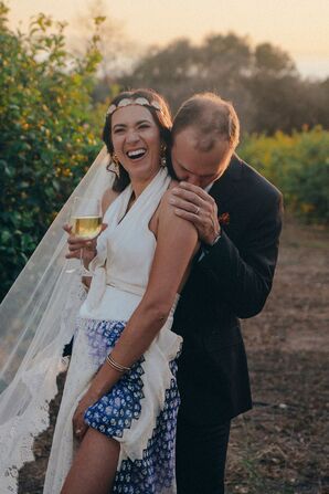 Bride in Custom, Multi-Piece Wedding Outfit and Headband With Groom in Suit Among Lemon Trees