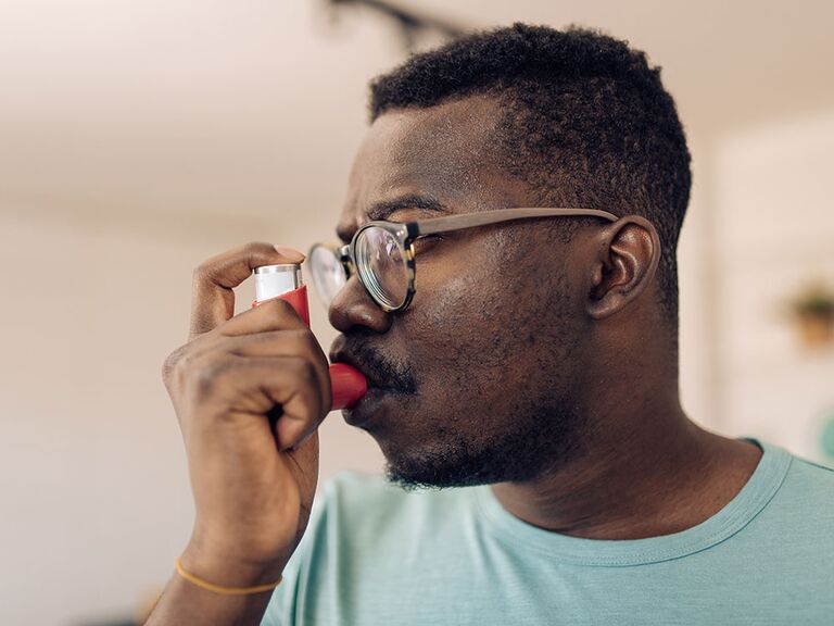 Man using asthma inhaler