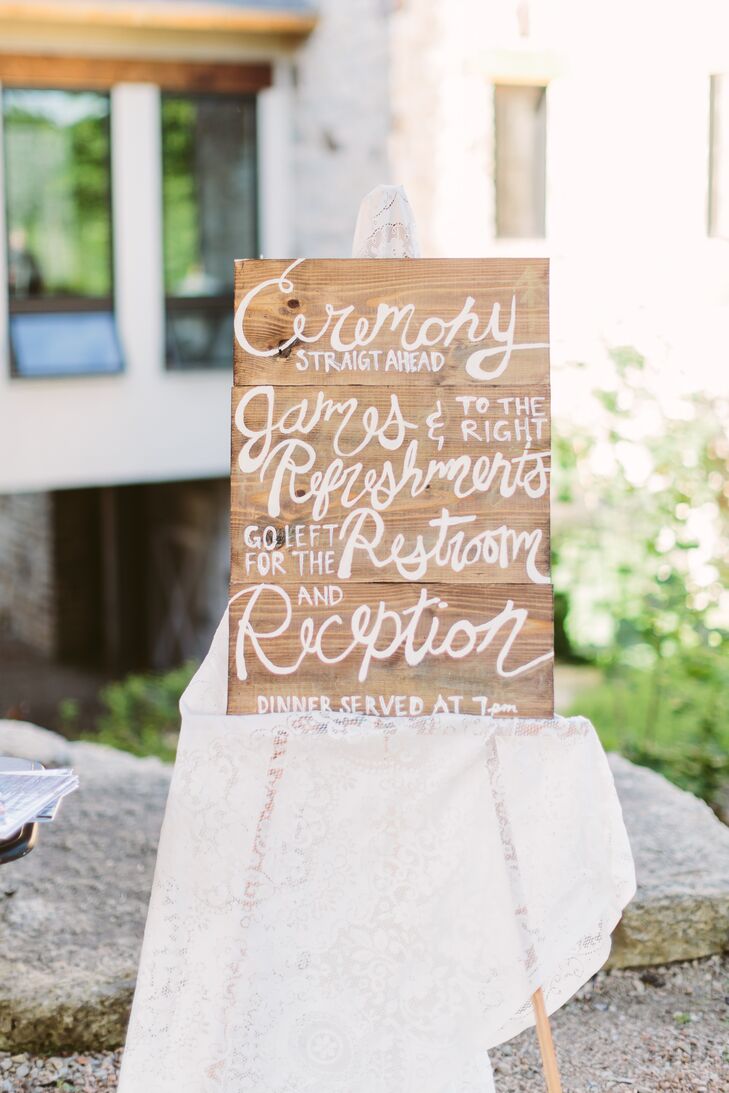 A wooden board displayed directions to different sections at Givens Farm, propped up on an easel covered with a white cloth accented in lace. This helped guests find their way throughout the day.