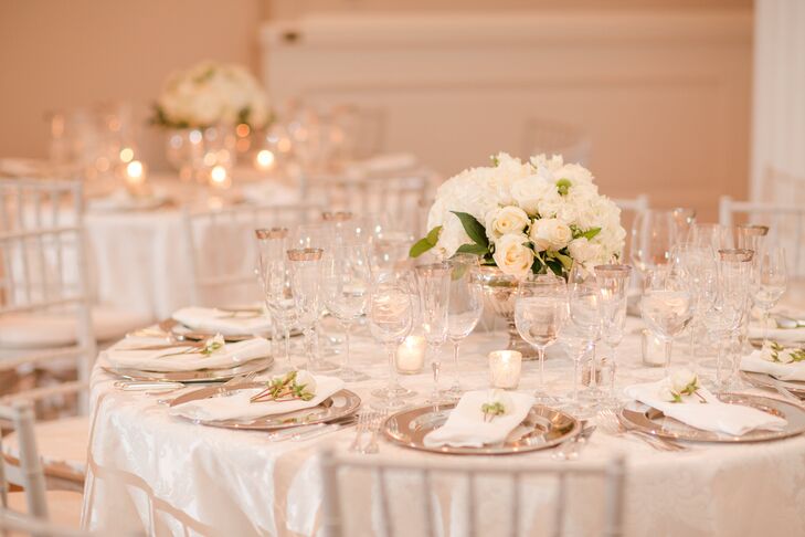 Centerpieces at this reception were simple, with white roses and hydrangeas arranged in mercury glass pedestal vases. The tables also had a few scattered votive candles.
