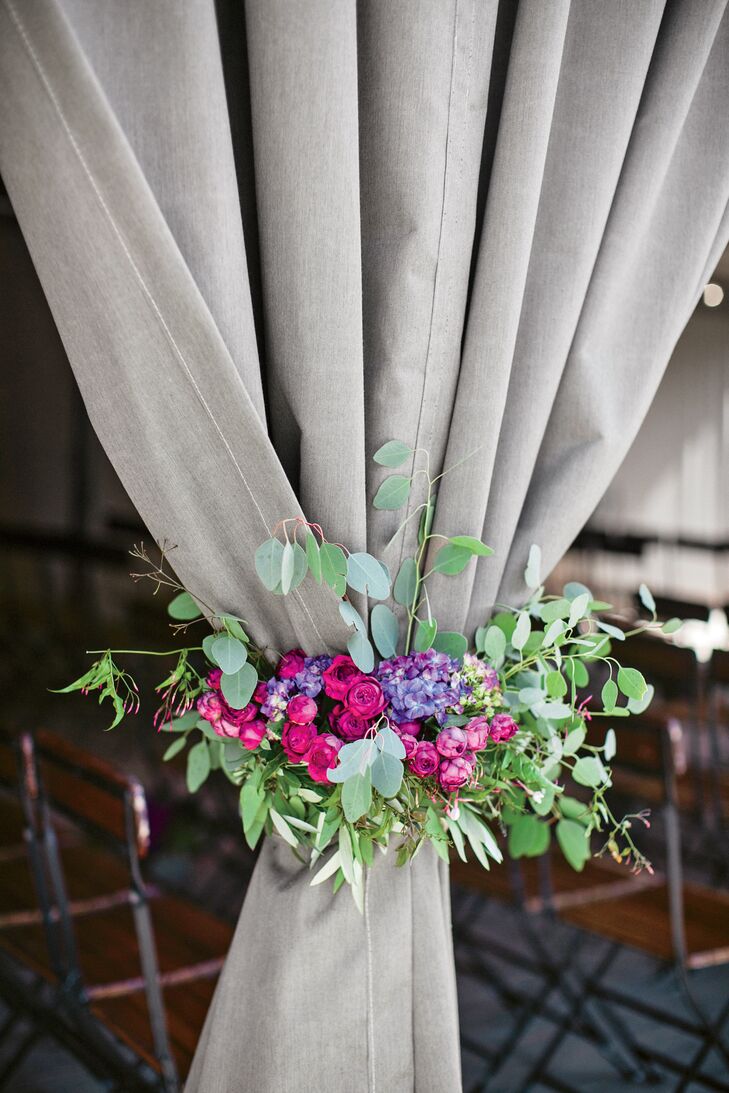 The ceremony took place in a covered pavilion overlooking the Sotero vineyard. Muslin drapes tied back with bunches of greenery and vibrant blooms softened the pavilion's wooden pillars.