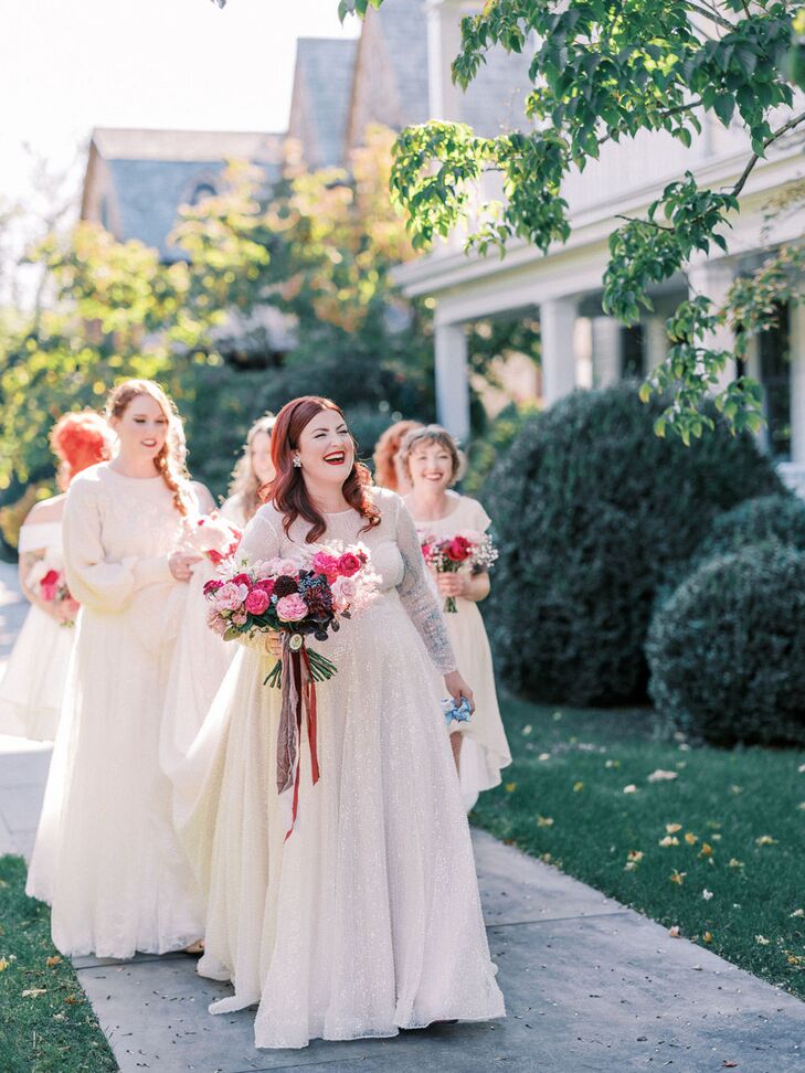 Bride in Illusion-Sleeved Gown and Pink Bouquet With Bridesmaids in White