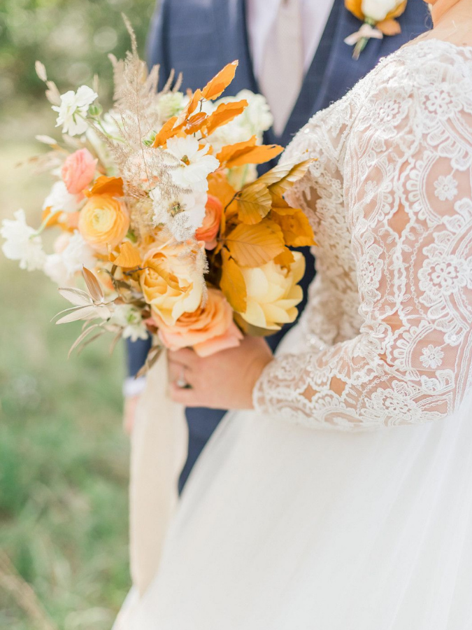 bride holding orange bouquet