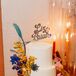 Three-Tier White Wedding Cake With Custom Name Topper and Dyed Flowers