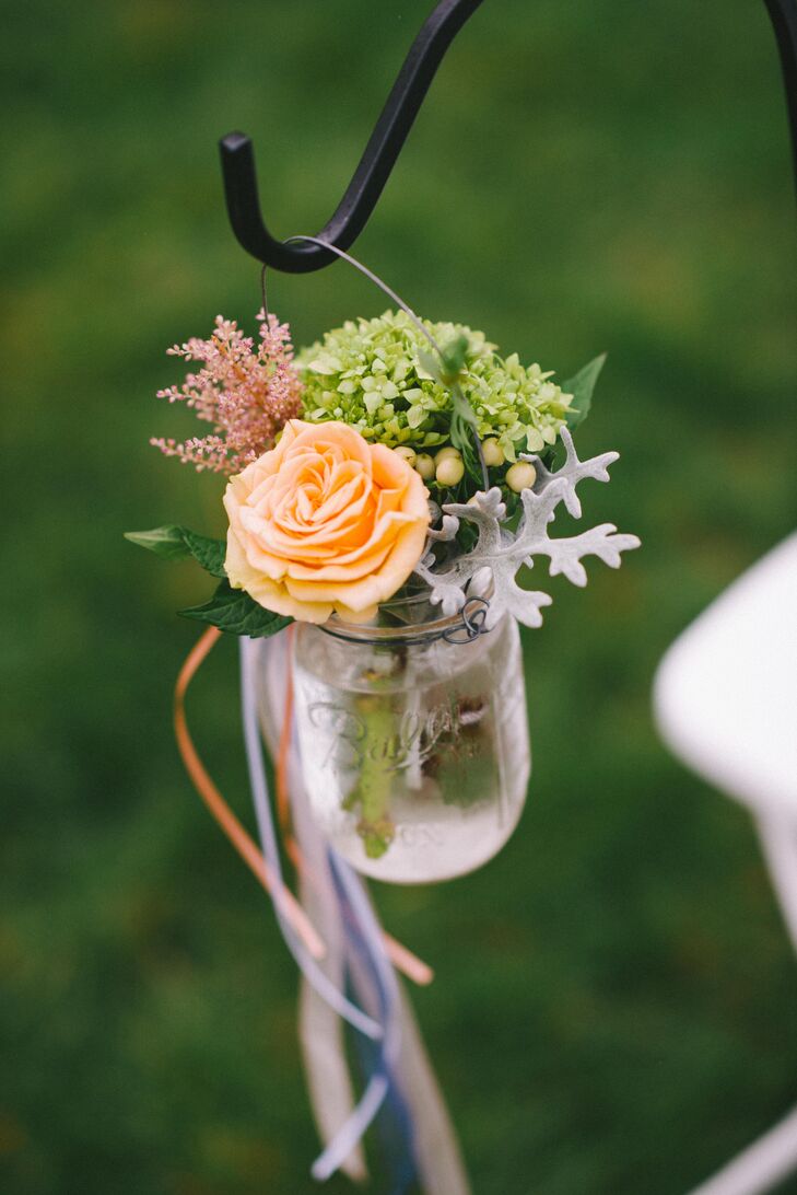 "We used a lot of mason jars to hold flowers and candles," says Emily. At the ceremony, jars were filled with peach roses, blush astilbe and silvery-green dusty miller leaves.