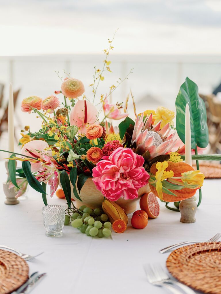 colorful small wedding centerpiece with yellow, pink and orange flowers and fresh fruit