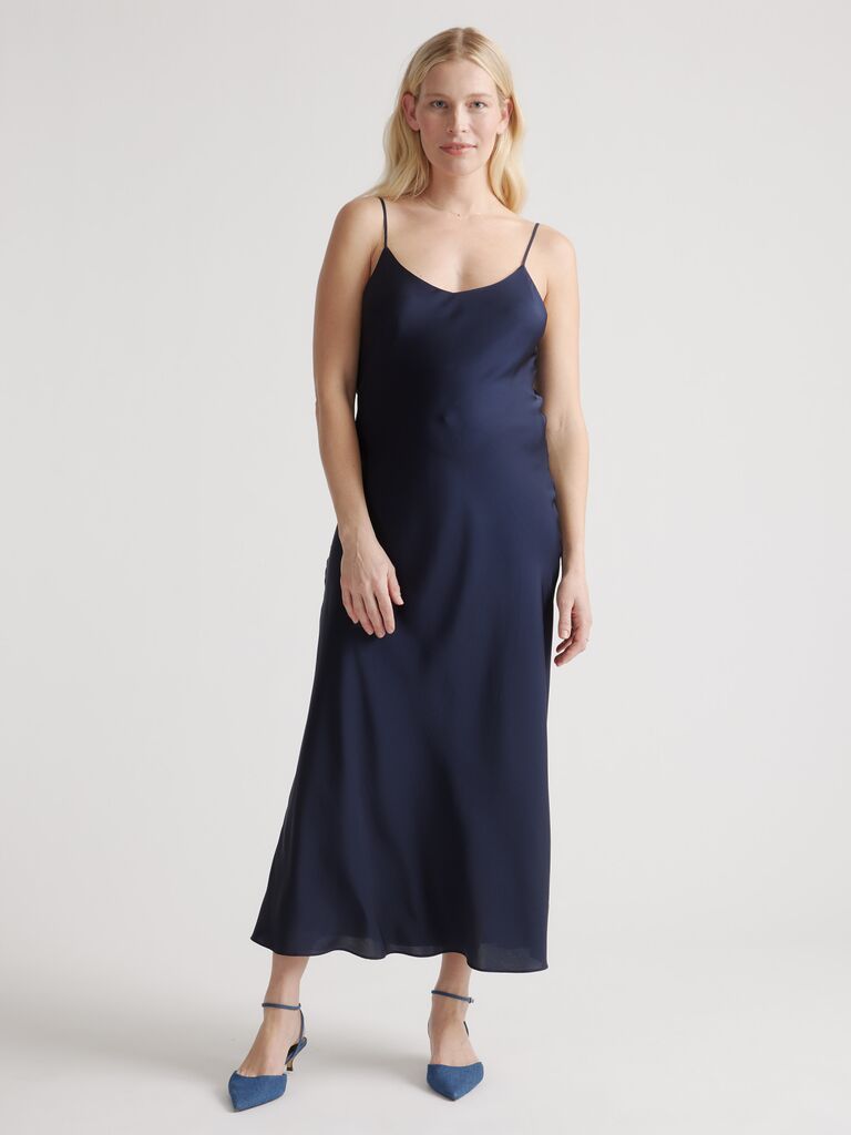 Model wears navy blue silk dress. 