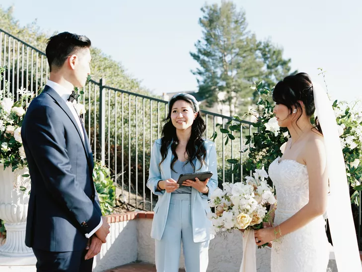 Couple with officiant during wedding ceremony