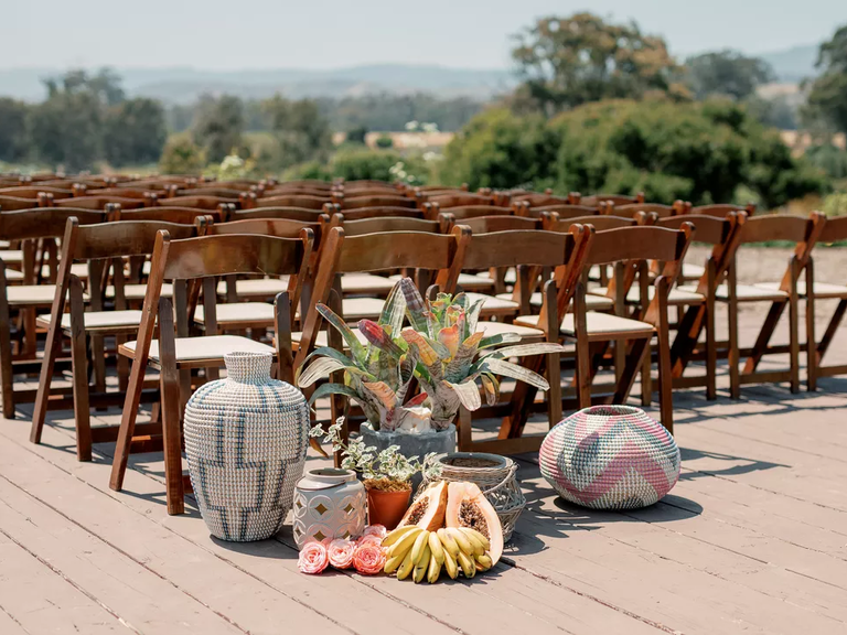 This southwestern US-inspired aisle arrangement includes flowers, baskets and pottery.