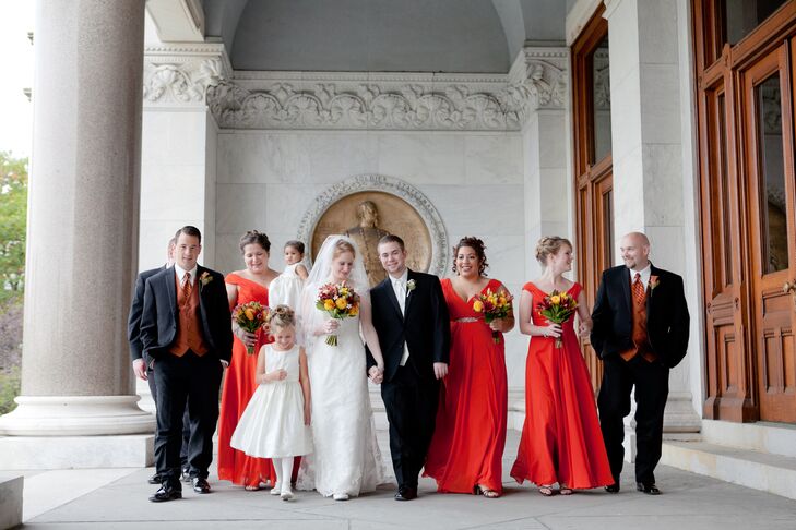 The bridesmaids worse floor-length dresses by Allure Bridals in a vibrant shade of burnt orange.