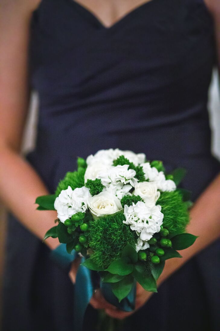To give the bridesmaids' bouquets a fresh pop of color, while keeping with the wedding's blue and emerald color palette, the couple's florists filled their bouquet with fluffy bunches of green trick and hypericum berries.