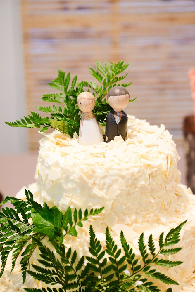 Their wedding cake showed off the day’s natural flair with multiple flavors. Buttercream frosting covered all three round tiers of red velvet cake. White chocolate shavings topped each one, resembling snow below natural fern leaves. To make the confection more personalized, Michael hand-painted each wooden figure for their topper.