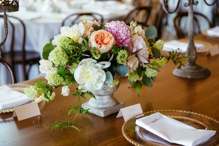 Kate and Jordan enlisted the help of the florists at Fleurs NYC to balance out the raw, industrial vibe of the Roundhouse’s Waterfall Room. Together they dreamed up arrangements of full blooms like peonies, garden roses and dahlias in shades of peach, pink and ivory.
