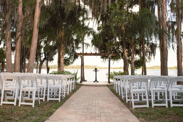 “Paradise Cove was the perfect location for our wedding,” Jami says. “The landscaping of the venue along with the view of the lake was perfect for the beach theme we were going for.” Not wanting to take away from the natural view, Jami and Chad simply used rows of white folding chairs to seat their guests and the venue’s wooden wedding arch as their decor. Two arrangements of white roses and purple astilbes also decorated the altar. “When your venue has so much natural beauty, you don't have to do much else,” Jami says.