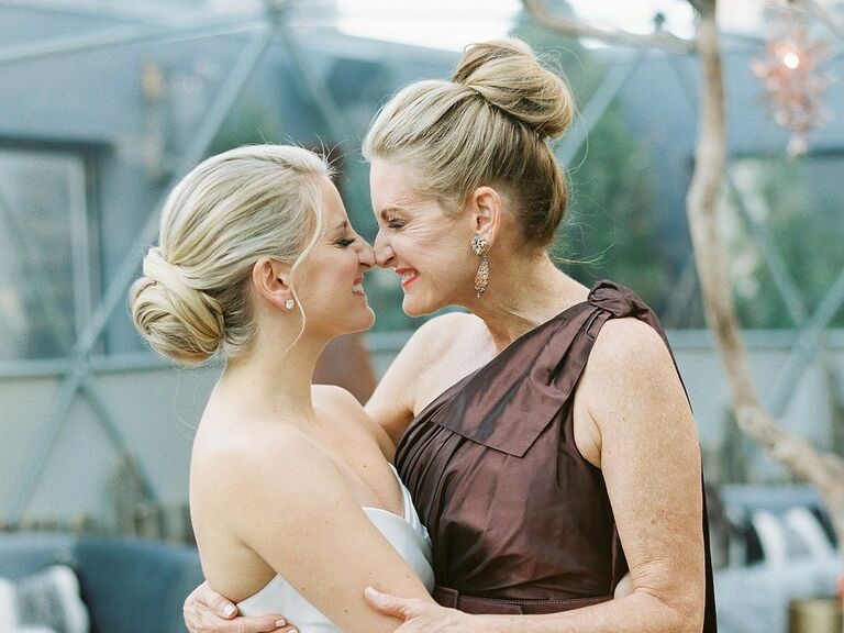 Mother of the bride wears her  hair in an elegant top knot. 