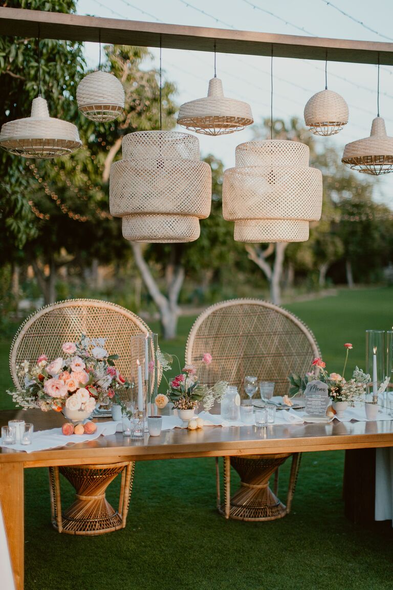 Sweetheart table with peacock chairs and woven chandeliers