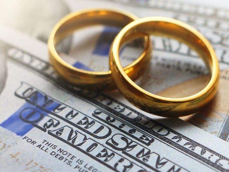 Wedding rings sitting on cash
