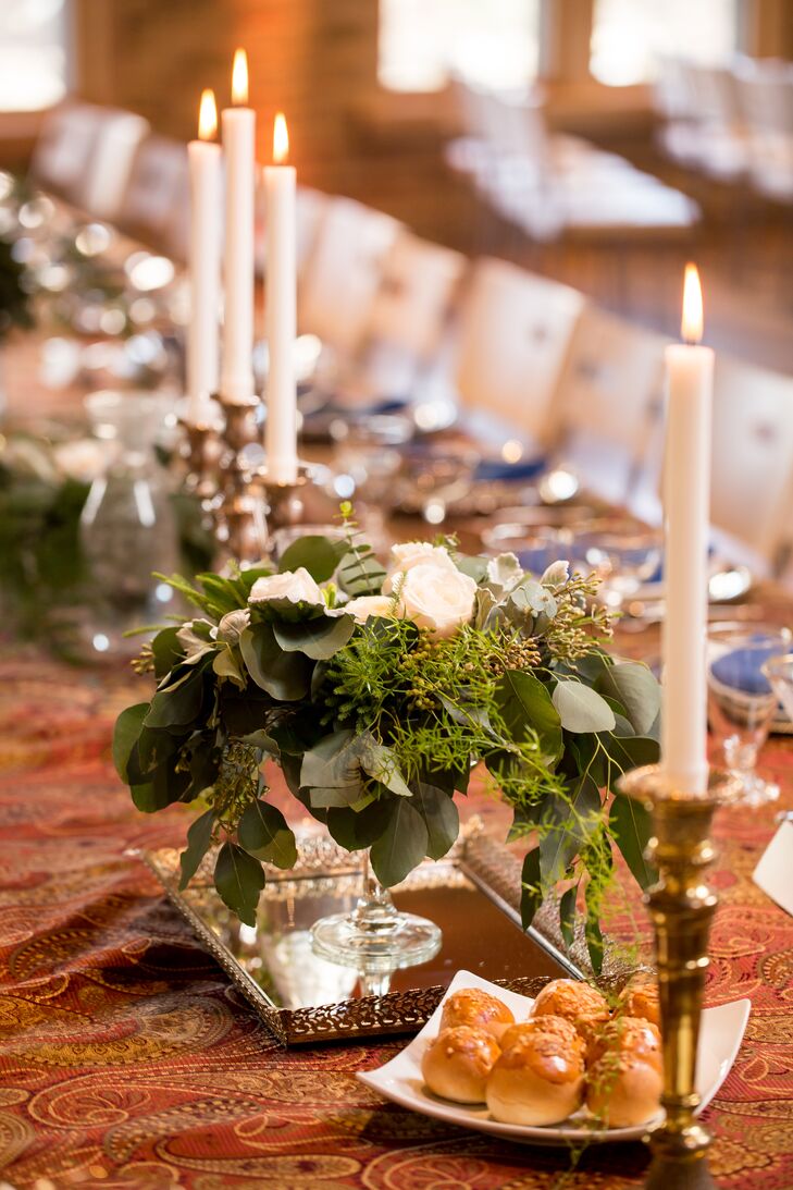 The long feasting table featured gold candlesticks with taper candles and low arrangements overflowing with moss and greenery.