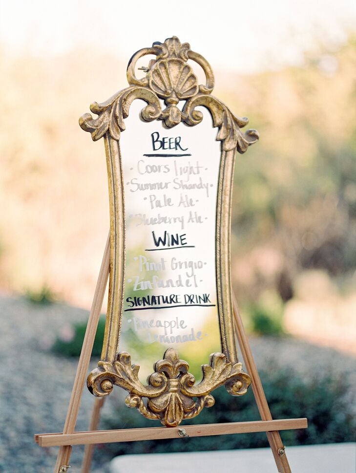 The cocktail menu was calligraphed on a gold-framed mirror.