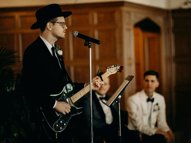Musician with electric guitar singing one of the best ballads for weddings.