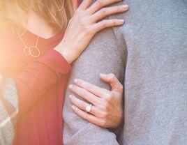 engaged couple linking arms