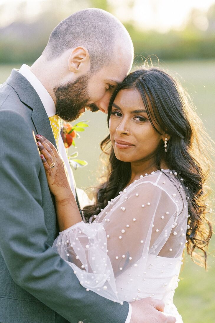 Bride With Loose Curls Hugging Groom During Golden Hour Photos