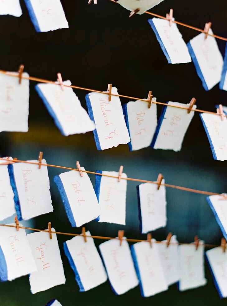 After cocktail hour, Christine and Addison and their guests headed to the reception tent where they found their seats with the help of dip-dyed escort cards created by Storied Events. Guests' names were scrawled on the cards in copper ink, and the cards were hung on a wooden frame that reflected the subtle rustic vibe of the fete in Manchester, Vermont.