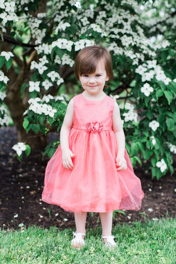 Brianna loved the idea of how coral would look against the Phipps Conservatory and Botanical Gardens in Pittsburgh, Pennsylvania. So every woman (and girl!) in the wedding party was dressed in a coral, peach or a true pink hue. The flower girl stood out from the others in a knee-length pink dress with a tulle overlay and rosette detailing along the waist.