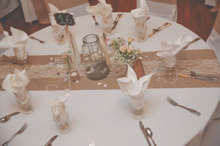 Jessica loved the reception venue at Bellecourt Manor, saying, "you'll find the high archways, French doors, extravagant chandeliers, and an old world baby grand piano take you back 100 years." Because the venue had such a natural vintage elegance, Jessica decorated modestly with glass lanterns, rose and baby's breath arrangements, chalk board table numbers, and accents of lace and pearls.