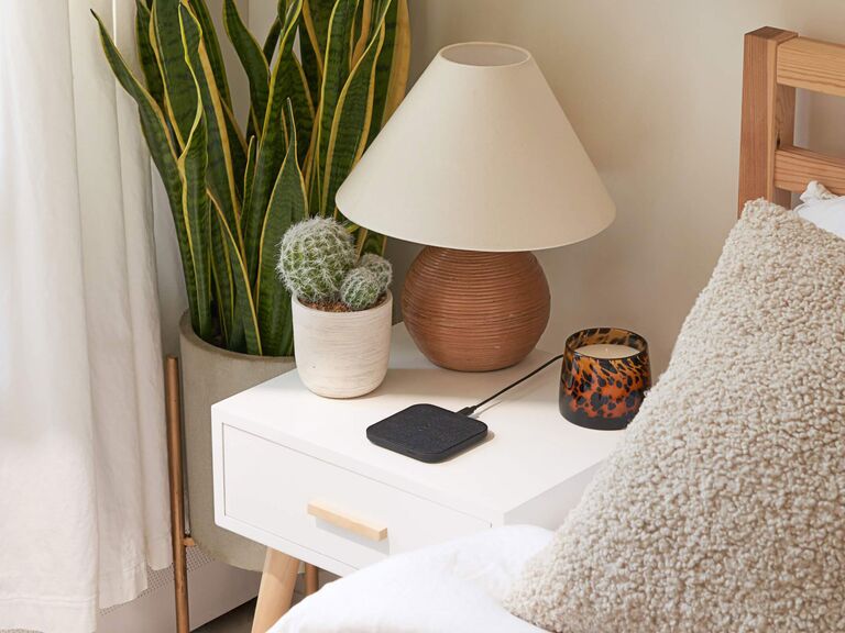 Small black wireless phone charger on nightstand bridesmaid gift idea