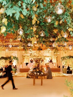 Tea Light Candles and Greenery Hanging From Ceiling at Rustic Reception