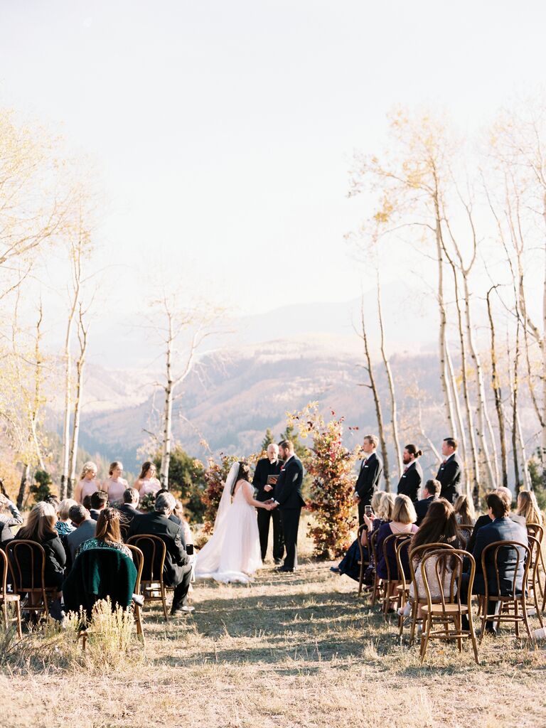 Bride and groom getting married at an outdoor rustic wedding ceremony.