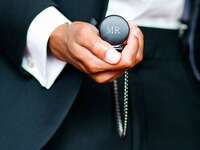 groom holding personalized pocket watch