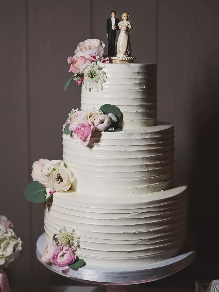 Elegant Three-Tier Wedding Cake With Vintage Topper