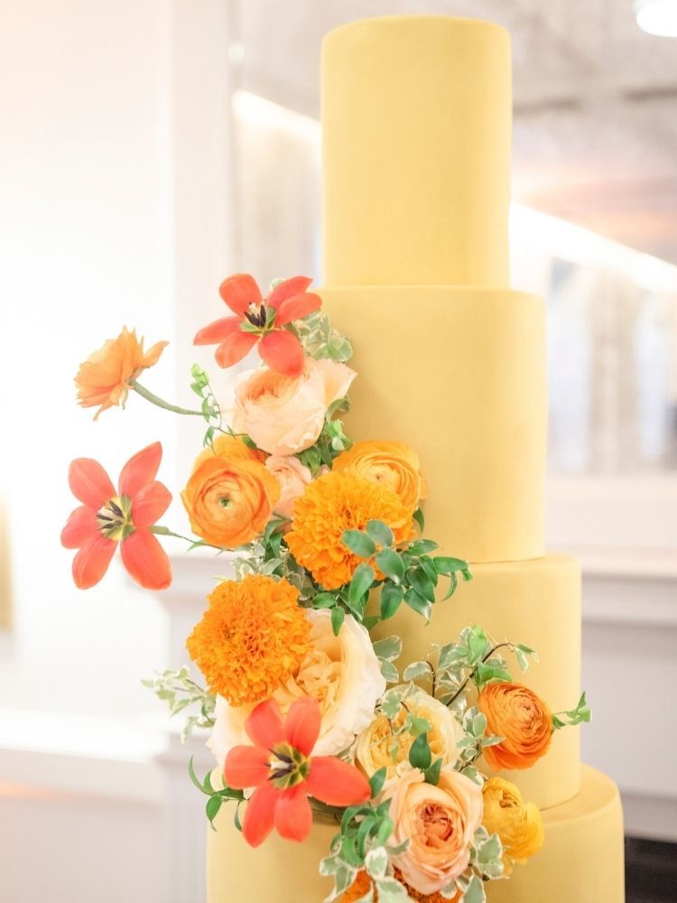 yellow wedding cake with orange flowers