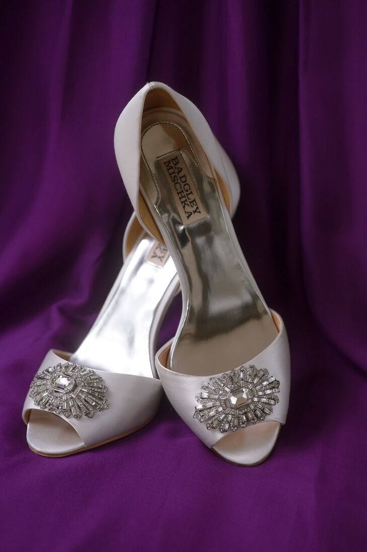 With a fun slit and Swarovski crystals already accenting her wedding dress, Irina chose a few simpler accessories. She wore a pair of ivory peep-toe wedding shoes with a silver detail by Badgley Mischka, a curled updo hairstyle and a vintage crystal hair accessory under her veil.
