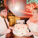 A bride and groom at their elopement party at a local college diner in Richmond, Virginia, with a heart-shaped retro-inspired wedding cake with "technically married" and a replica of an insurance card to funnily honor their logical reason for eloping.