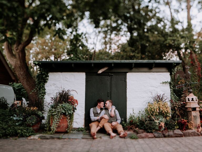 Couple embrace in a garden for their bohemian photo shoot. 
