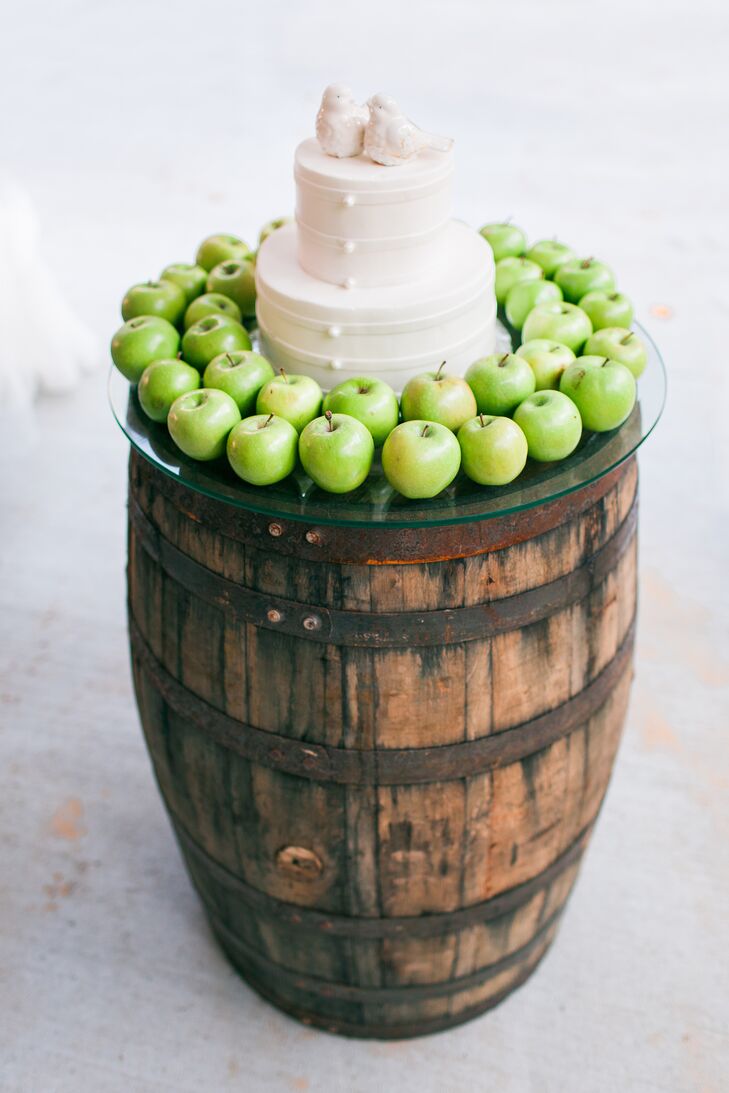 This vintage-inspired wedding cake sat atop a distressed wooden barrel on a round glass slab. Madison placed green apples around the confection to pull in some color.