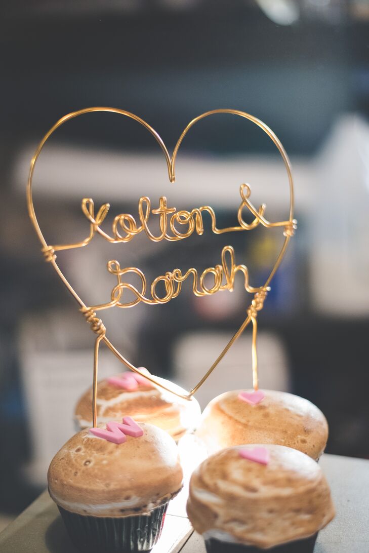 S'mores cupcakes were browned on top and displayed on a stand at the reception for dessert. On top of the assortment was a wire sign that spelled out "Kolton & Sarah."