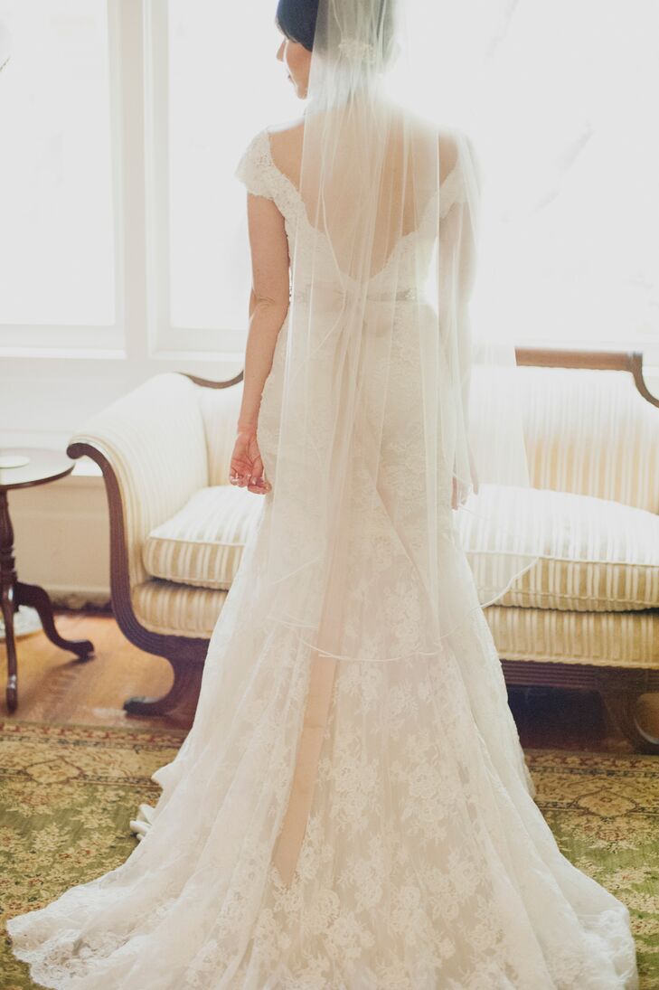Katy wore an Allure Bridals dress that combined a vintage and romantic look. The entire gown covered in lace had a deep V-neck back with buttons going down the middle. Her fingertip-length veil added an elegant touch.