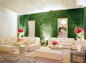 Cocktail Sitting Area with White Lounge Furniture, Bright Flowers and Boxwood Wall Installation
