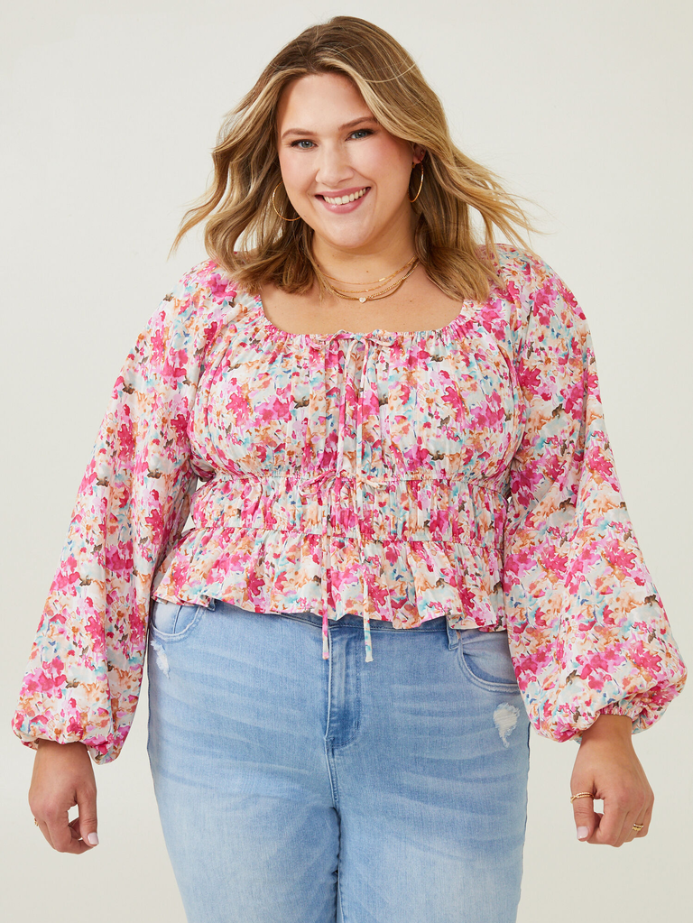 A model shows off this fun and flirty floral peasant top.
